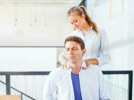 office worker getting massage on his workplace. pain and stress relief photo