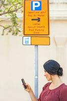 woman walking phone parking board photo