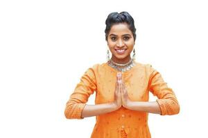 Beautiful south indian woman doing namaste gesture while looking at camera, isolated over white background photo