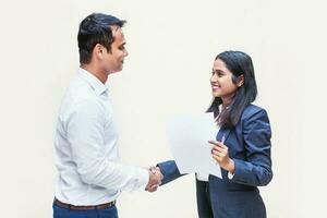 Two indian office colleagues discussing a document on white background photo