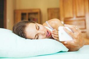 Woman using her phone as alarm clock photo