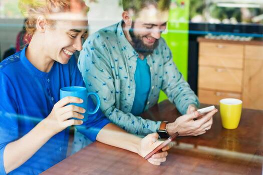 woman showing something on her smart phone to a man in cafe photo