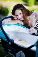 Young mother with her sleeping baby outdoors photo