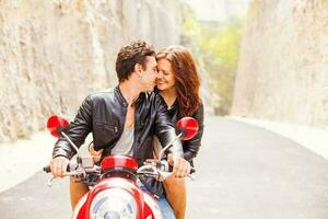 Beautiful caucasian couple riding a motorbike together photo