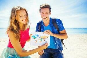 couple holding a map with travel destinations photo