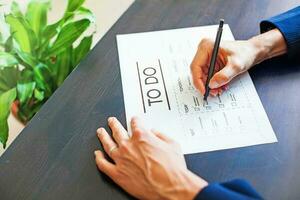 Woman checking office tasks as completed in to-do list photo