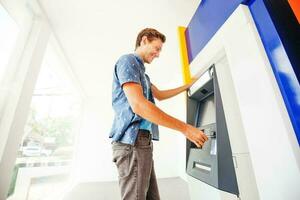 man using atm to withdraw cash photo