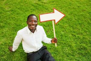 black man sitting on a grass with an arrow photo
