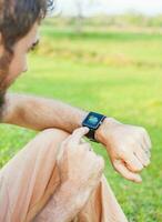 Man clicking on his smart watch showing a weather app photo