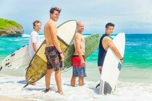 group of surfers on a beach photo