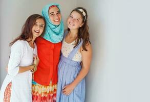 Tres amigos de diferente religiones en pie felizmente juntos foto