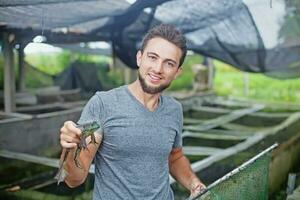 Farmer on frog farm in Bali photo