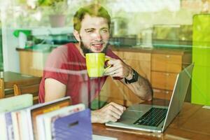 hombre utilizando su ordenador portátil - ver mediante el ventana foto