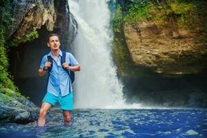 hombre teniendo un aventurero rastreo cerca el cascada foto