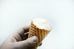 An ice cream cone in the young man's hand. Delicious ice cream in your hand. photo