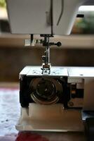 un blanco de coser máquina en el habitación. Procesando de ropa con un de coser máquina. foto
