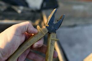 Pliers in the hands of a master. Pliers with a plastic handle. photo