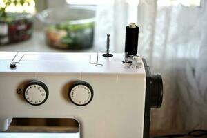 A white sewing machine in the room. Processing of clothes with a sewing machine. photo