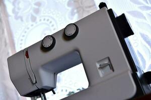 A white sewing machine in the room. Processing of clothes with a sewing machine. photo