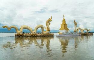 The Golden pagoda and Twin Naga an iconic landmark in Phayao lake, Thailand. photo