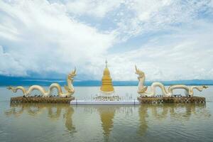 The Golden pagoda and Twin Naga an iconic landmark in Phayao lake, Thailand. photo