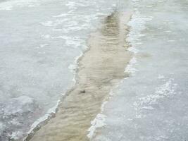 Erosion from flood waters. Spring stream. Snow washed away by a stream photo