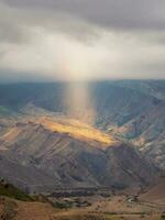 místico ligero de cielo en el oscuro montañas. dramático cielo en montaña picos místico antecedentes con dramático montañas. vertical vista. foto