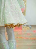 Shiny hem of the stage white skirt for the holiday. Animator costume at a children's party, close-up. photo