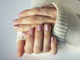 Fashionable pink manicure design in the hand. photo