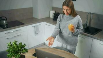 Woman standing in home cozy kitchen use laptop do freelance work, chatting with someone, answering e-mail. Concept of remote work video