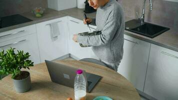 mujer mirando receta en línea mientras Cocinando video