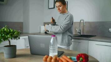 mujer mirando receta en línea mientras Cocinando video