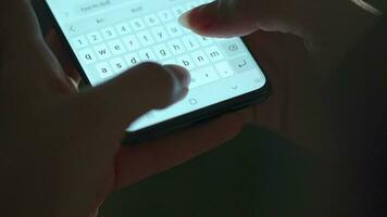 kvinna händer skriver text på smartphone närbild. använder sig av smartphone stänga upp i de kväll video