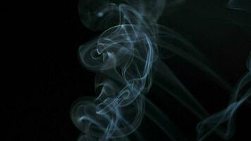 Abstract smoke rises up in beautiful swirls on black background. video