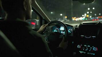 Man driving car through the streets of night city. View from the back seat of the car video