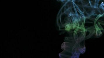 Abstract smoke rises up in beautiful swirls on black background. video