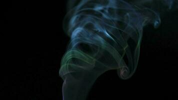 Abstract smoke rises up in beautiful swirls on black background. video