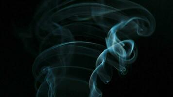 Abstract smoke rises up in beautiful swirls on black background. video