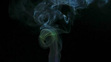 Abstract smoke rises up in beautiful swirls on black background. video