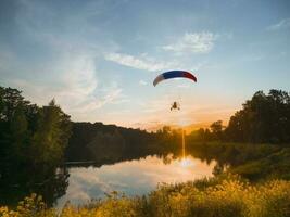 Extreme sports. Powered parachute in the evening against the blue sky photo