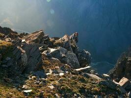 Dangerous couloir. Colorful sunny landscape with dark cliff and big rocky mountains and epic deep gorge. photo