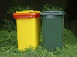 Multi-colored containers for separate garbage collection in a green place photo