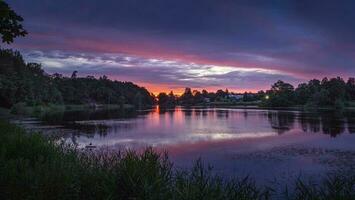 Beautiful panoramic view of the purple sunset on the lake. photo