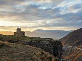 Stone mosque on the background of the mountains. The evening light shines beautifully on the old stone mosque. Hunzah. Dagestan. photo