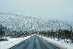 ártico nieve Derecho invierno la carretera mediante el colinas foto