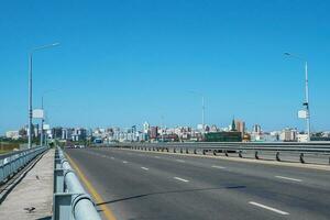 City bridge, asphalt highway. Modern buildings with empty road under blue sky, Barnaul, Russia. photo