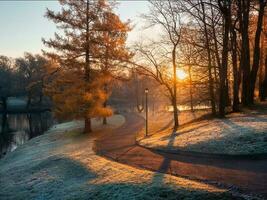 Atmospheric November morning landscape with sunrise, frost and winding road in the park. photo