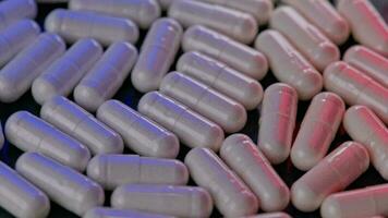 looped spinning full frame macro medical background of white drug pill capsules video