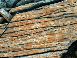 Layered mountain texture. Stone texture. Cross section of rocks. Geological layers. Colored layers of stones in section of the mount, different rock formations and soil layers. photo