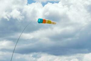 viento calcetín. viento designante en contra el azul nublado cielo. viento manga volador cerca arriba. foto